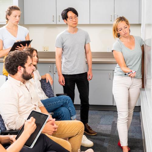 researchers standing at a whiteboard